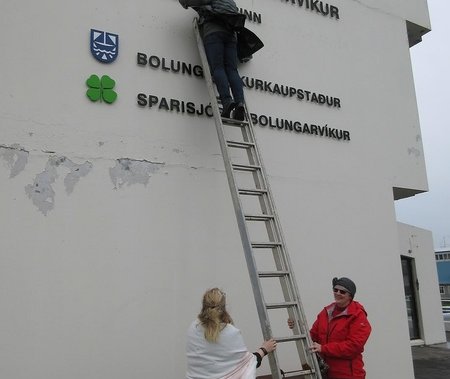 Bæjarstjórinn í Bolungarvík hylur skilti sýslumanns (Mynd BB.is)